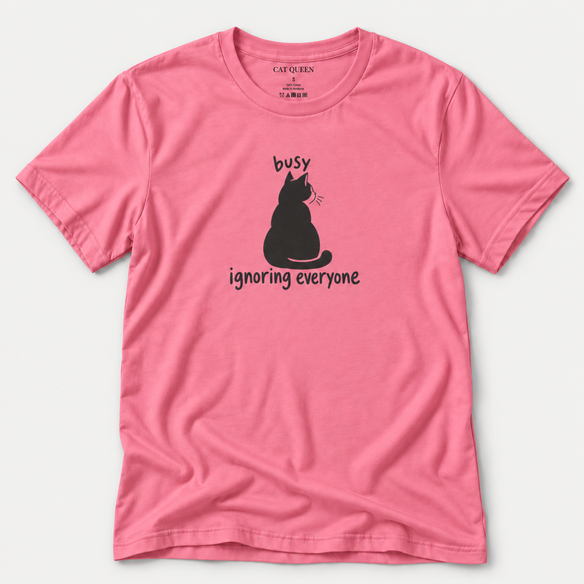 Busy Ignoring Everyone T-Shirt in Charity Pink with black back-facing cat and text design.