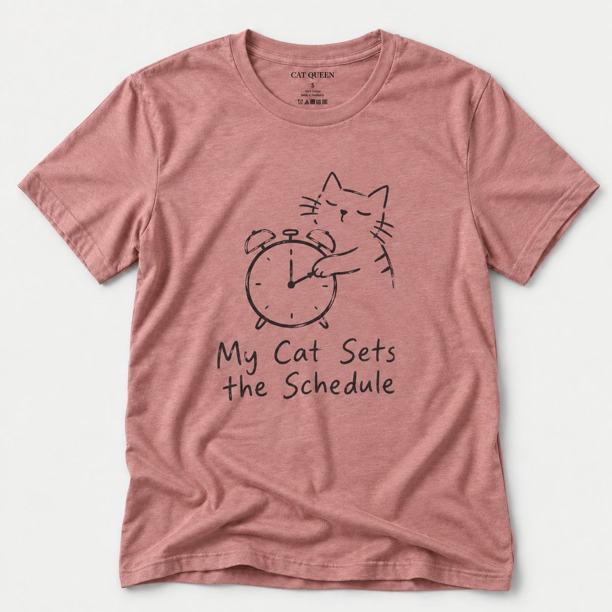 Cat Sets the Schedule T-Shirt in Heather Mauve with cat on an alarm clock graphic.