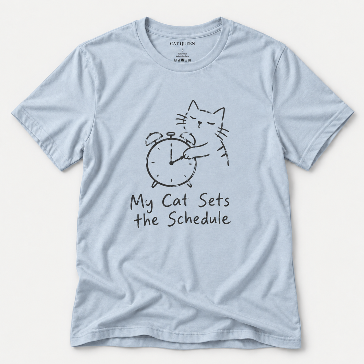 Cat Sets the Schedule T-Shirt in Light Blue with cat on an alarm clock graphic.