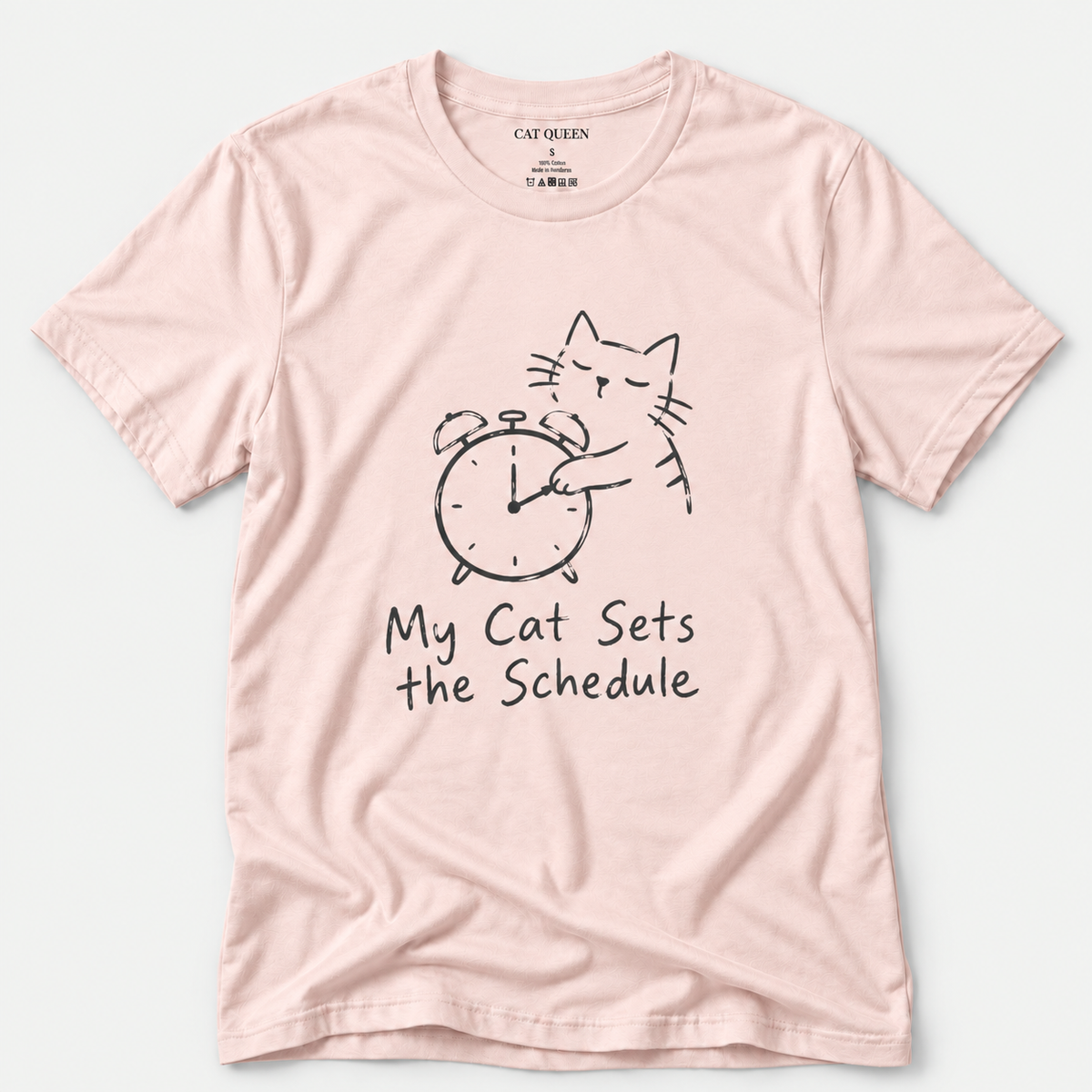 Cat Sets the Schedule T-Shirt in Soft Pink with cat on an alarm clock graphic.
