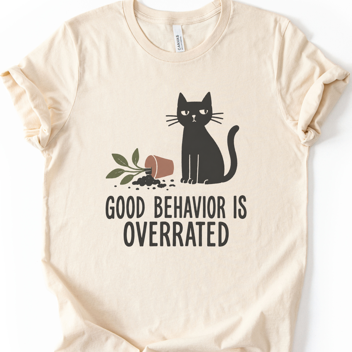 Good Behavior Cat T-Shirt in Natural with black cat and knocked-over plant graphic.