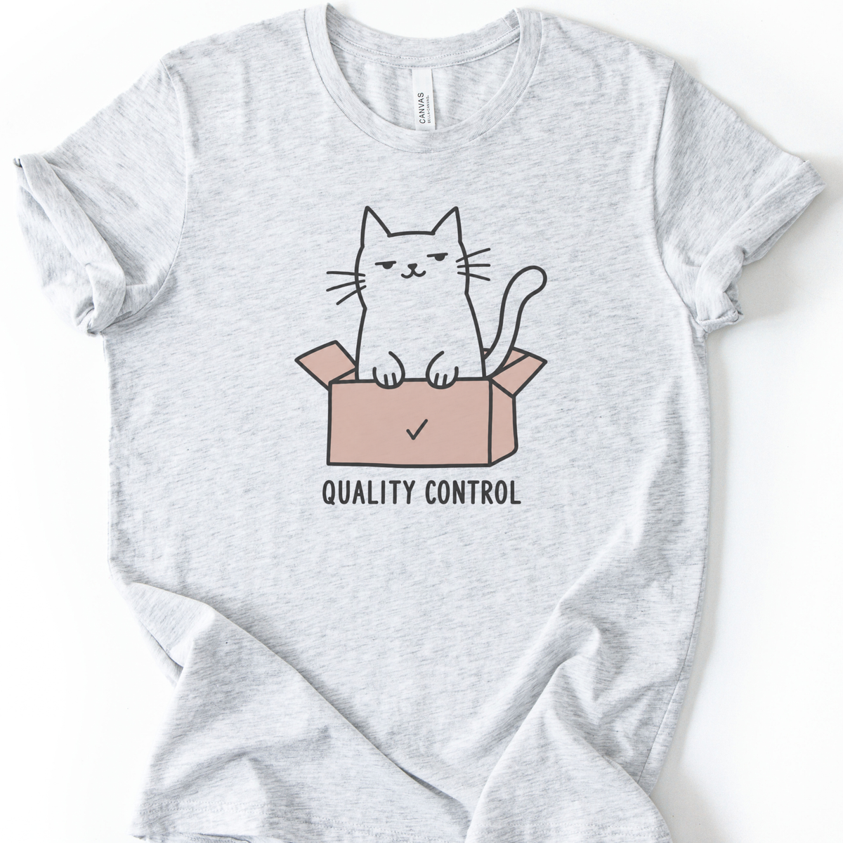 Quality Control Cat T-Shirt in Ash with cat sitting in a pink box graphic.
