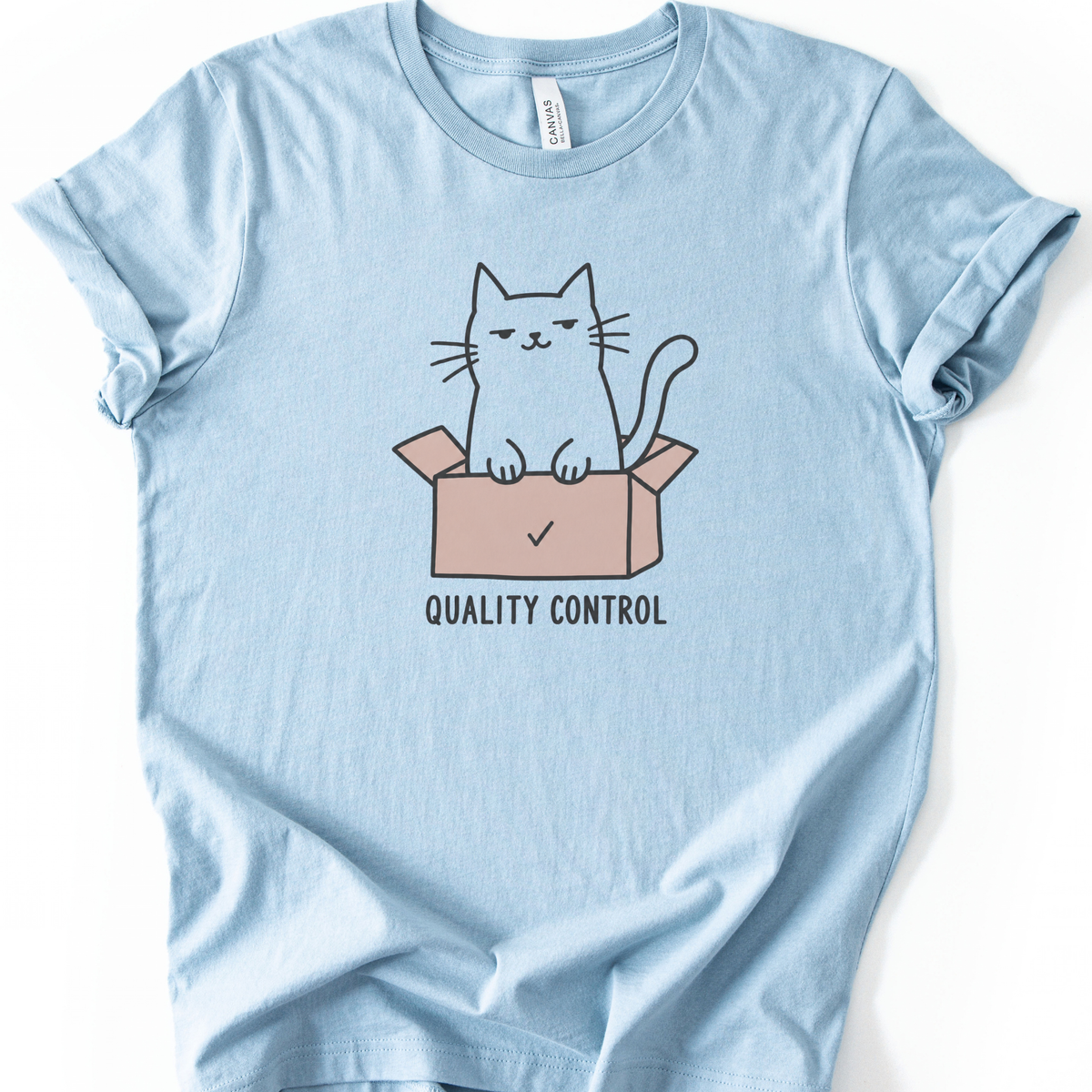 Quality Control Cat T-Shirt in Light Blue with cat sitting in a pink box graphic.